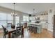 Well-lit kitchen boasting stainless steel appliances, white cabinets, a central island, and an adjacent dining area at 457 Skiles Ct, Suwanee, GA 30024