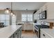 Well-lit kitchen featuring white cabinets, stainless steel appliances, and a large island at 457 Skiles Ct, Suwanee, GA 30024