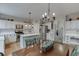 Open kitchen featuring white cabinets, stainless steel appliances, a center island, and an adjacent dining table at 457 Skiles Ct, Suwanee, GA 30024