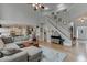 Spacious living room featuring hardwood floors, a staircase, and a seamless transition to a modern kitchen at 457 Skiles Ct, Suwanee, GA 30024