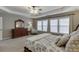 Stylish main bedroom with a cozy seating area, dresser, and large windows with natural light at 457 Skiles Ct, Suwanee, GA 30024