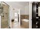 Bathroom featuring a tub, walk-in shower with glass doors and tile surround, and access to the main bedroom at 5523 Glenridge Ne Park, Atlanta, GA 30342