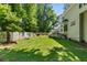 Expansive backyard featuring lush green grass, mature trees, and a cozy fire pit area at 120 Ashewoode Downs Ln, Alpharetta, GA 30005