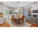 Open dining area with hardwood floors, large windows, and a view of the living room fireplace at 120 Ashewoode Downs Ln, Alpharetta, GA 30005