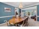 Elegant dining room featuring blue walls, a chandelier, and a wooden table with seating for six at 120 Ashewoode Downs Ln, Alpharetta, GA 30005
