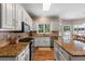 Spacious kitchen featuring white cabinets, granite countertops, stainless steel appliances, and backyard views at 120 Ashewoode Downs Ln, Alpharetta, GA 30005