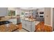 Open-concept kitchen featuring granite countertops, an island, stainless steel appliances, and hardwood floors at 120 Ashewoode Downs Ln, Alpharetta, GA 30005