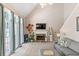 Bright living room with a fireplace, tall windows, and a comfortable gray sofa with throw pillows at 120 Ashewoode Downs Ln, Alpharetta, GA 30005