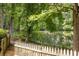 Scenic view of a tree-lined backyard with a rustic wooden fence and water views, creating a peaceful oasis at 2030 Darien Park Dr, Roswell, GA 30076