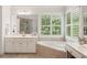 Bright bathroom features double vanity sinks, soaker tub, and window with shutters at 2030 Darien Park Dr, Roswell, GA 30076
