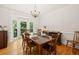 Elegant dining room featuring wainscoting, a chandelier, and a bay window with backyard views at 2030 Darien Park Dr, Roswell, GA 30076