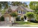 Charming two-story brick home with a well-manicured lawn, mature trees, and a two-car garage at 2030 Darien Park Dr, Roswell, GA 30076