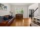 Inviting living room featuring gleaming hardwood floors, a cozy leather sofa, and natural light at 2030 Darien Park Dr, Roswell, GA 30076