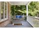 Relaxing porch swing with a comfy neutral and blue pillows, offering a tranquil outdoor retreat at 2030 Darien Park Dr, Roswell, GA 30076