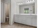 Bright bathroom vanity with double sinks, white cabinets, and tile floor at 261 Mahone Dr, Lilburn, GA 30047