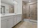 Bright bathroom with double sink vanity, white cabinets, and glass shower with tile surround at 261 Mahone Dr, Lilburn, GA 30047