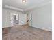 Bright bedroom with neutral carpet, tray ceiling, and double doors to bath and closet at 261 Mahone Dr, Lilburn, GA 30047