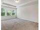 A carpeted bedroom with large windows and tree views at 261 Mahone Dr, Lilburn, GA 30047