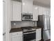 A modern kitchen featuring stainless steel appliances and light gray backsplash at 261 Mahone Dr, Lilburn, GA 30047