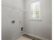 A bright laundry room with tile floors, window, and shelving at 261 Mahone Dr, Lilburn, GA 30047