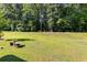 Large, grassy backyard lined with mature trees, ideal for outdoor activities at 525 Clinton Dr, Temple, GA 30179