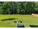 Large, grassy backyard lined with mature trees, ideal for outdoor activities at 525 Clinton Dr, Temple, GA 30179