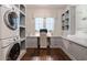Bright laundry room featuring front loading washer and dryer, white cabinetry, wood floors, and desk space at 101 Morgan Ln, Canton, GA 30115