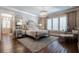 Elegant main bedroom with a crystal chandelier, wood floors, neutral decor, and a tufted headboard at 101 Morgan Ln, Canton, GA 30115