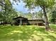 Charming home with a screened porch, surrounded by lush green lawn and mature trees at 125 Cannongate Cir, Sharpsburg, GA 30277