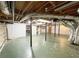 Unfinished basement with green painted flooring, exposed duct work and beams, and visible utilities at 125 Cannongate Cir, Sharpsburg, GA 30277