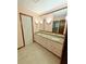 Bathroom with double sinks, granite countertop, white cabinets, large mirror, and light pink painted walls at 125 Cannongate Cir, Sharpsburg, GA 30277