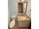 Bathroom featuring a single sink with granite countertop, a toilet, and a mirror with wood trim at 125 Cannongate Cir, Sharpsburg, GA 30277