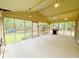 Spacious screened-in porch with an outdoor grill, ceiling fans, and backyard views through the screened windows at 125 Cannongate Cir, Sharpsburg, GA 30277