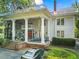 Stately gray home boasts tall white columns, balconies, a brick staircase, and mature landscaping at 893 Piedmont Ne Ave # 5, Atlanta, GA 30309