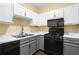 The yellow kitchen features white and gray cabinets, with appliances including a black range and microwave at 893 Piedmont Ne Ave # 5, Atlanta, GA 30309