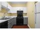 A compact kitchen featuring white and gray cabinets, with modern appliances including a black range and microwave at 893 Piedmont Ne Ave # 5, Atlanta, GA 30309