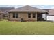 Exterior view of home's backyard and screened porch, and well-maintained lawn at 115 Court Xing, Locust Grove, GA 30248