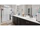 Bathroom vanity with double sinks and white countertops, complemented by a tiled shower with glass door at 115 Court Xing, Locust Grove, GA 30248