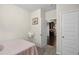 Neutral bedroom featuring a bed and view to the kitchen with dark cabinets and flooring at 115 Court Xing, Locust Grove, GA 30248