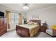 Comfortable bedroom with wood furniture, window with curtains, and neutral decor at 115 Court Xing, Locust Grove, GA 30248