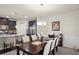 Open-concept dining area next to kitchen featuring a stylish table, chairs, and modern lighting at 115 Court Xing, Locust Grove, GA 30248