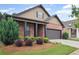 Well-manicured front lawn with mature landscaping complements the home's brick and siding exterior at 115 Court Xing, Locust Grove, GA 30248