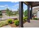 Inviting front porch with dark wood columns and views of the street and landscaped front yard at 115 Court Xing, Locust Grove, GA 30248