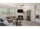 Cozy living room with a fireplace, neutral tones, and plenty of natural light from large windows at 115 Court Xing, Locust Grove, GA 30248