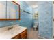 Nautical-themed bathroom with blue walls, a vanity, and an accent mirror at 1950 Wenlok Ne Trl, Marietta, GA 30066