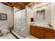 Well-lit bathroom features tiled floors, vanity, and shower with patterned curtain at 1950 Wenlok Ne Trl, Marietta, GA 30066
