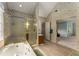 Bathroom featuring tub, glass-enclosed shower, and views into the main bedroom at 1950 Wenlok Ne Trl, Marietta, GA 30066