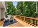 Wood deck with outdoor seating and a grill surrounded by lush green trees at 1950 Wenlok Ne Trl, Marietta, GA 30066