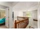Upstairs hallway with wood railing and view of front entry and a bright window at 1950 Wenlok Ne Trl, Marietta, GA 30066