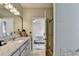 Modern bathroom with granite countertops, glass shower, and a glimpse into the bedroom at 2220 Lily Valley Dr, Lawrenceville, GA 30045